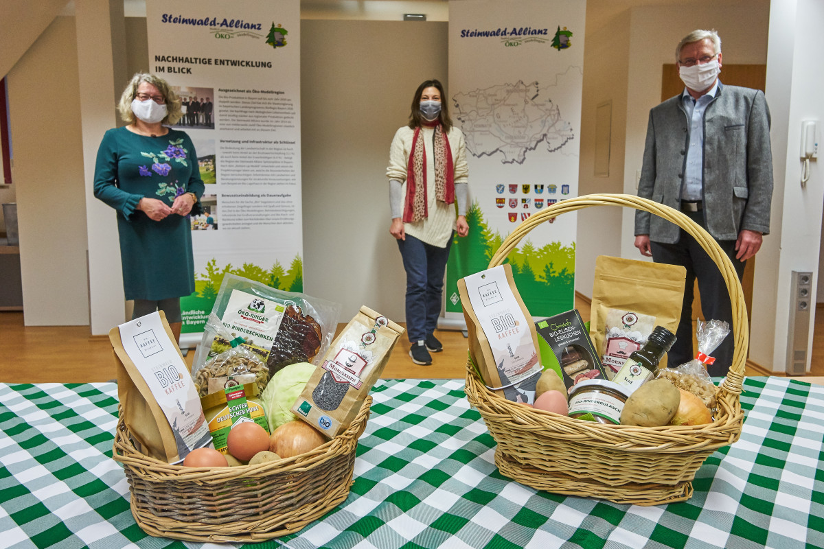 Eva Gibhardt, Elisabeth Waldeck (Projektmanagerinnen der Öko-Modellregion Steinwald) und Johannes Reger (1. Vorsitzender der Steinwald-Allianz) stellen den Bio-Geschenkkorb vor.