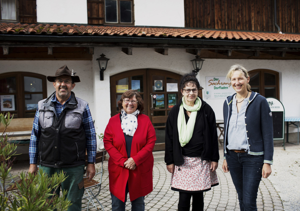 Ein Mann, drei Frauen stehen vor dem Sachranger Dorfladen