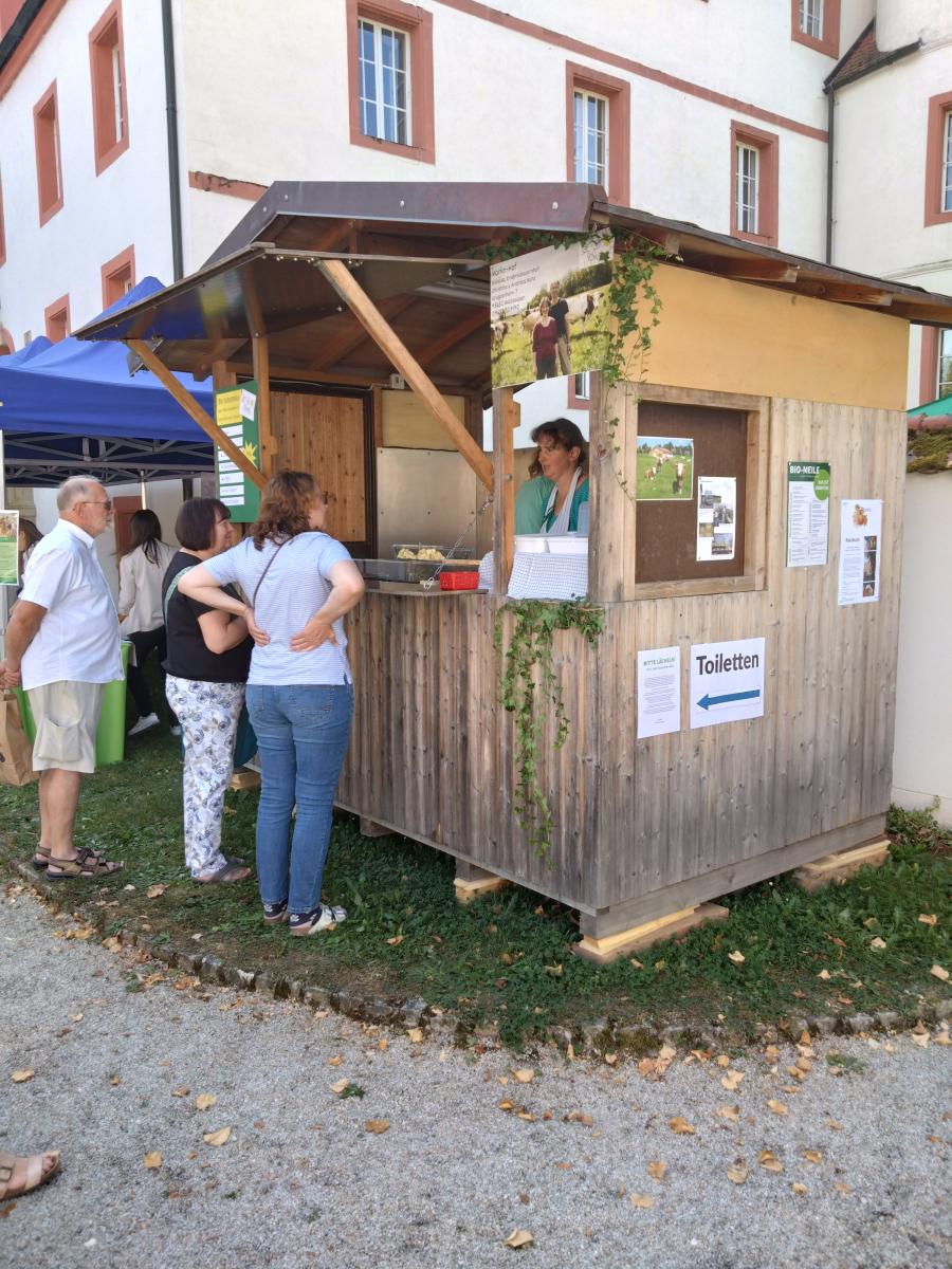 ein Marktstand mit Verkäufern und Käufern