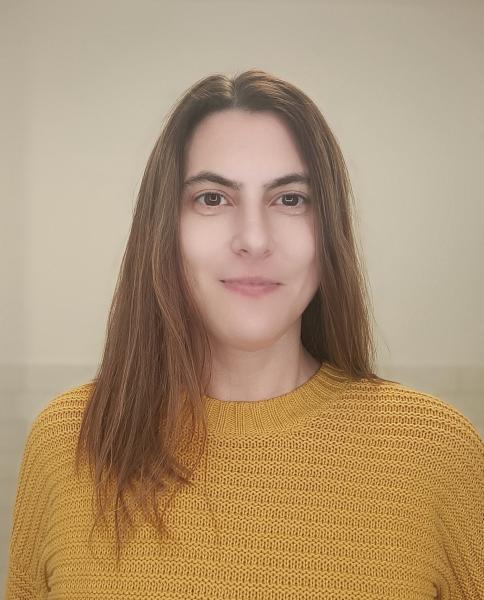 Person mit langen Haaren und gelbem Pulli
