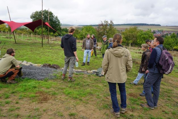 Besuchergruppe auf landwirtschaftlicher Fläche