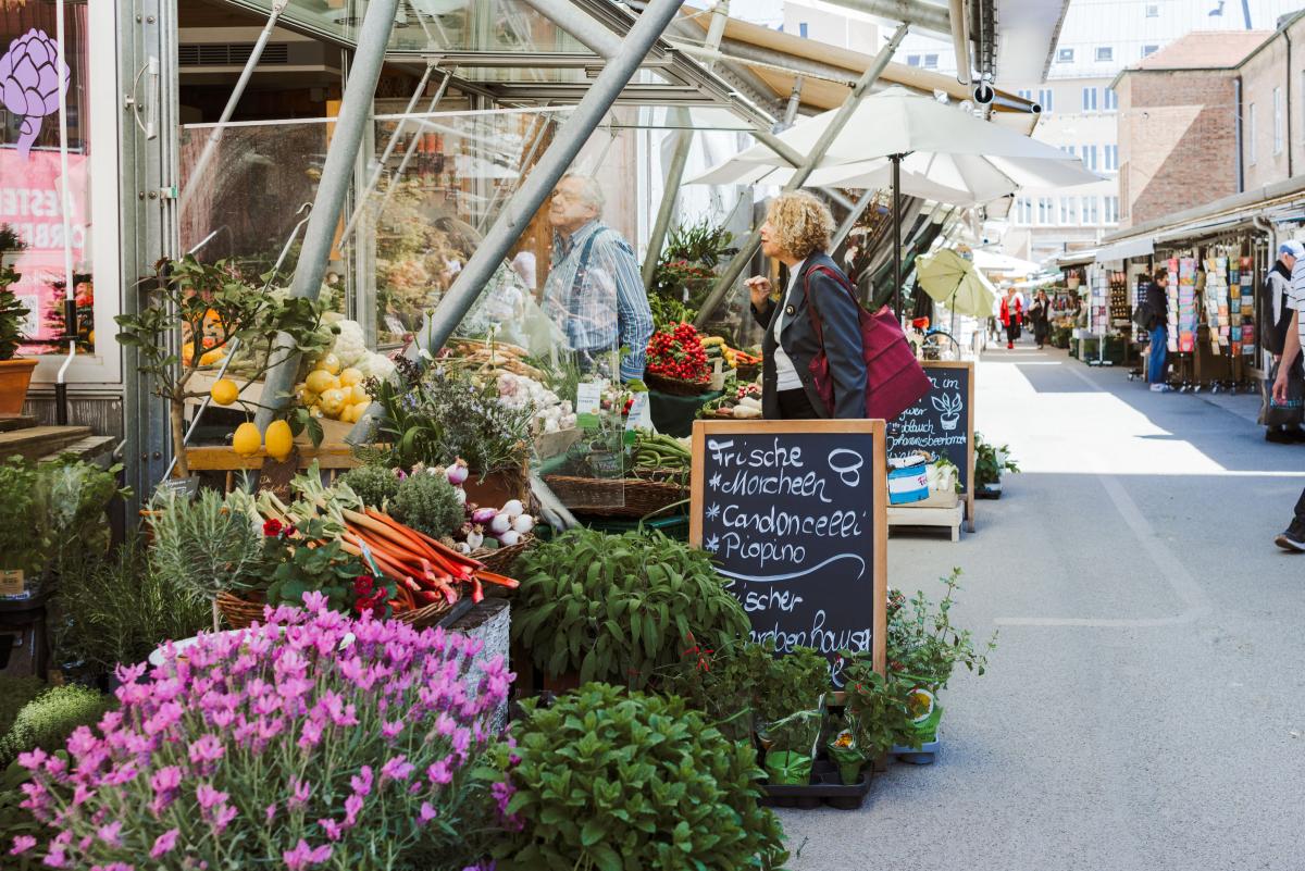 Das Foto zeigt mehrere Verkaufsstände mit Blume und anderen Produkten.