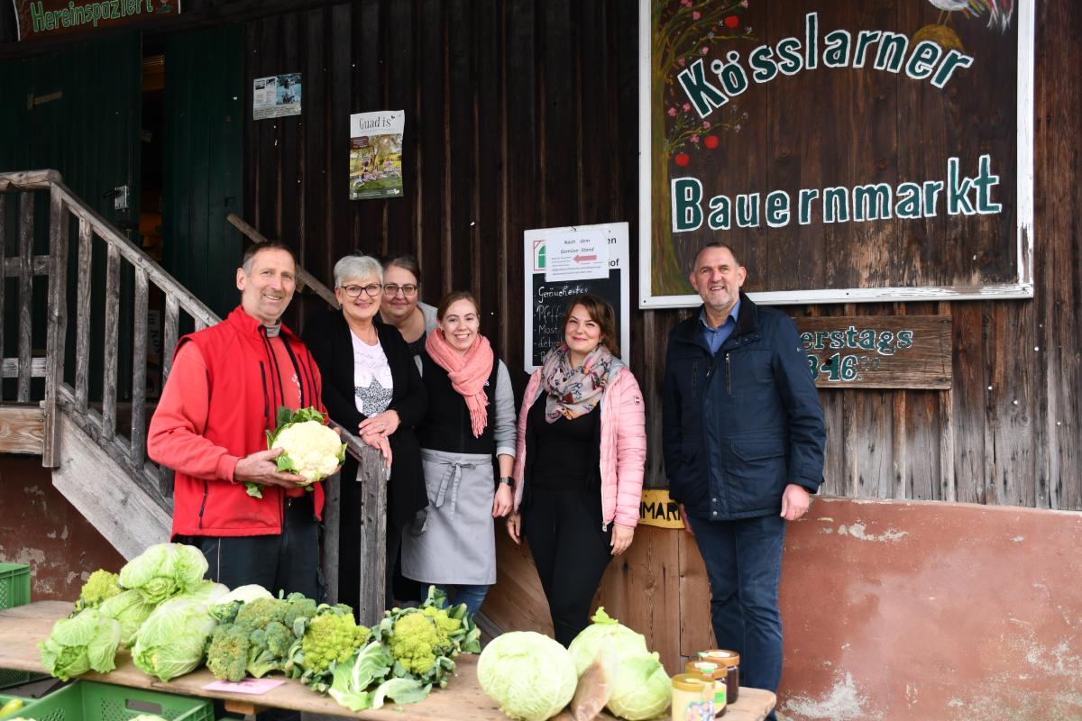 Gruppe von Menschen steht vor dem Eingang des Kößlarner Bauernmarktes