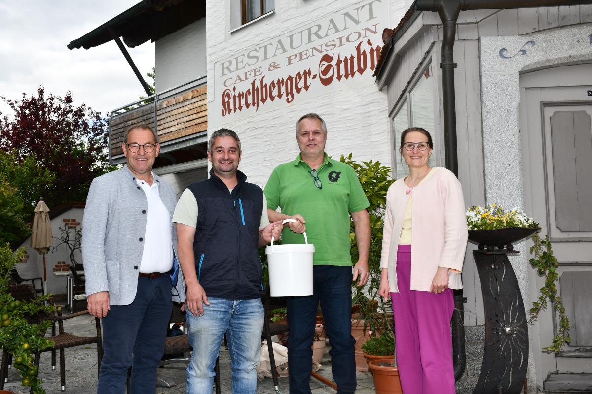 Franz Dankesreiter überreicht Wilfried Maier einen Eimer Bio-Heumilch