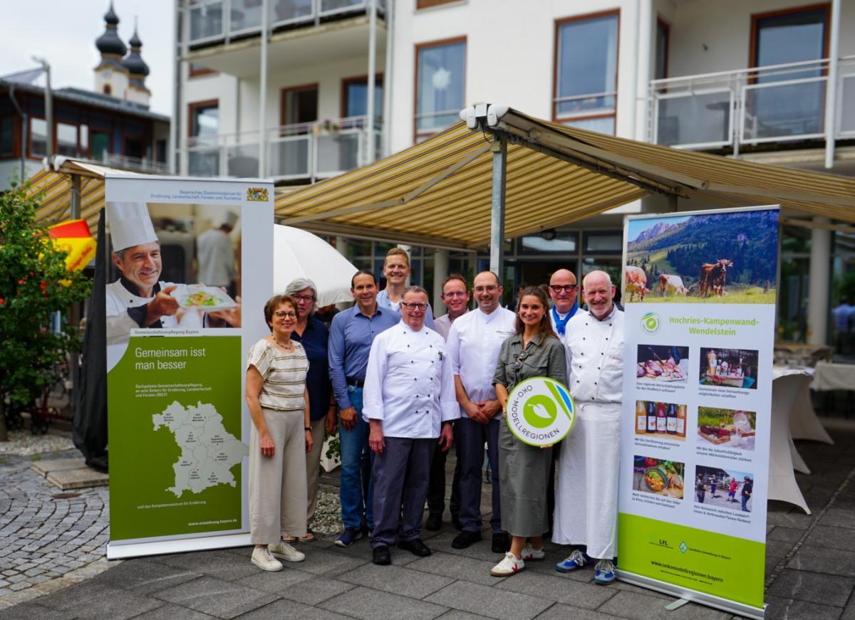 Menschen mit Stellwänden vor Haus
