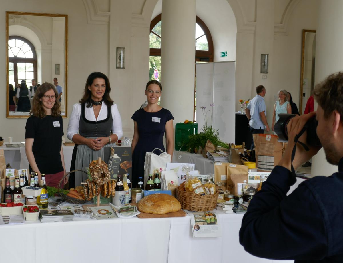 Stand mit Produkten aus den Regionen, drei Frauen dahinter, Fotograf