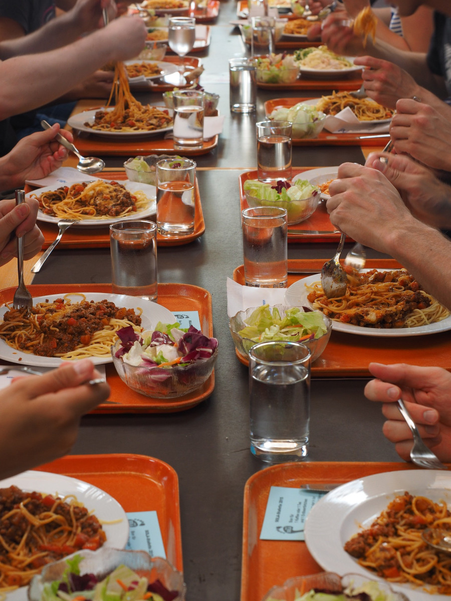 Essensituation in der Kantine: Tabletts mit Spaghetti Bolognese