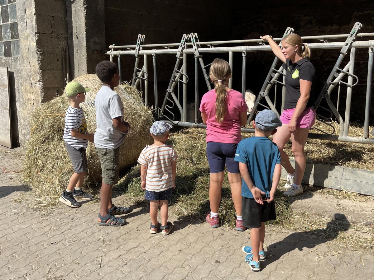 Fünf Kinder und eine Erwachsene vor dem Kuhstall