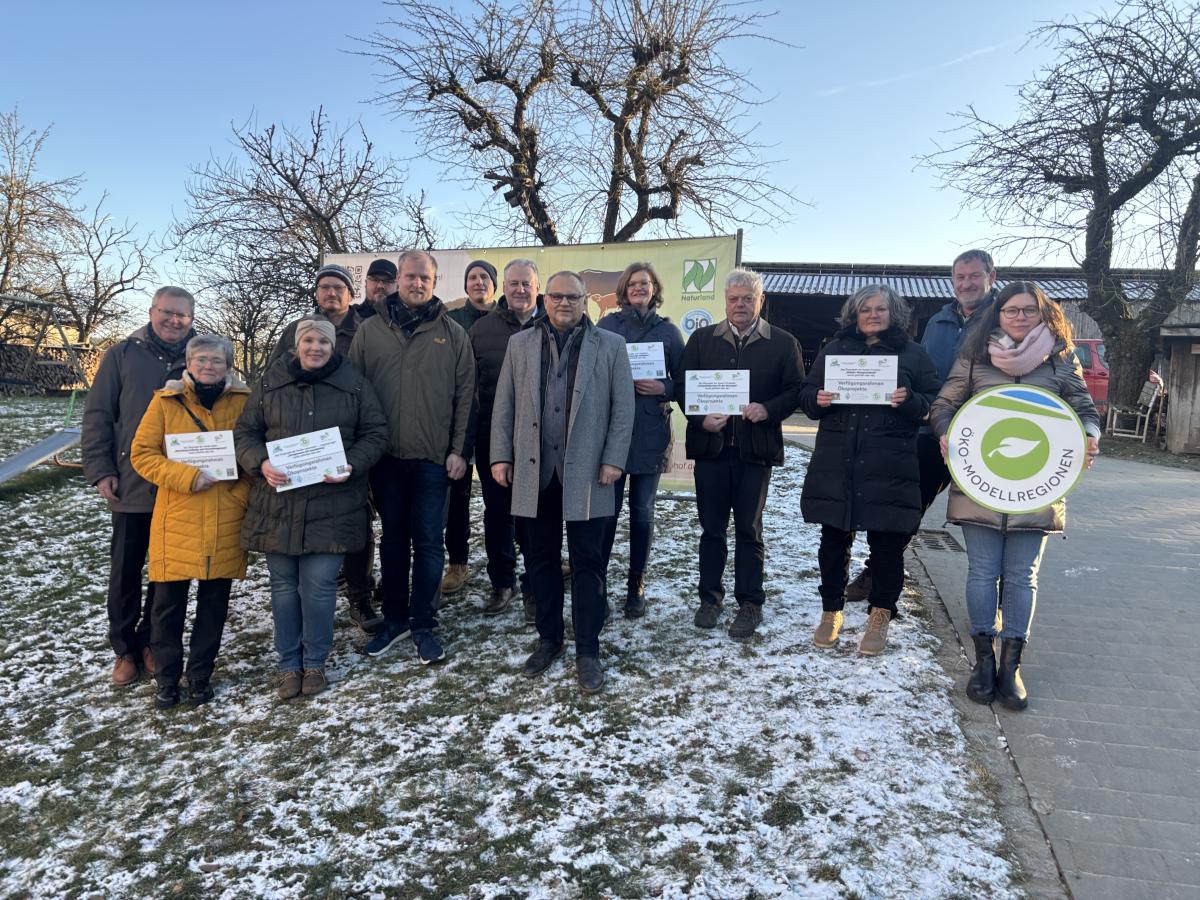 Mehrere Menschen stehen im Halbkreis und halten Schilder in die Höhe.