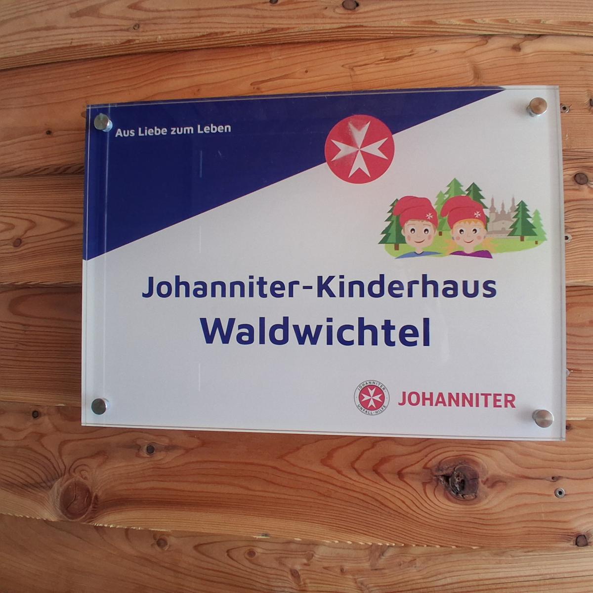ein buntes Schild am Eingangsbereich eines Kindergartens