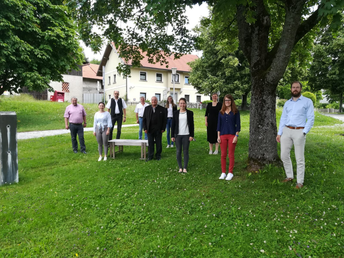 Lenkungsgruppe trifft sich im Rathaus Hutthurm, Beteiligte stehen zum Foto unter einem Baum vor einer Blumenwiese