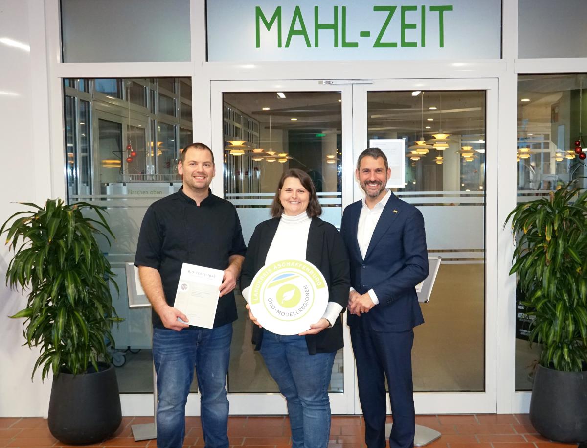 Landrat Dr. Alexander Legler, Öko-Modellregion-Managerin Inga Gräf und der Kantinenbetreiber Andreas Amrhein mit der Zertifizierungs-Urkunde