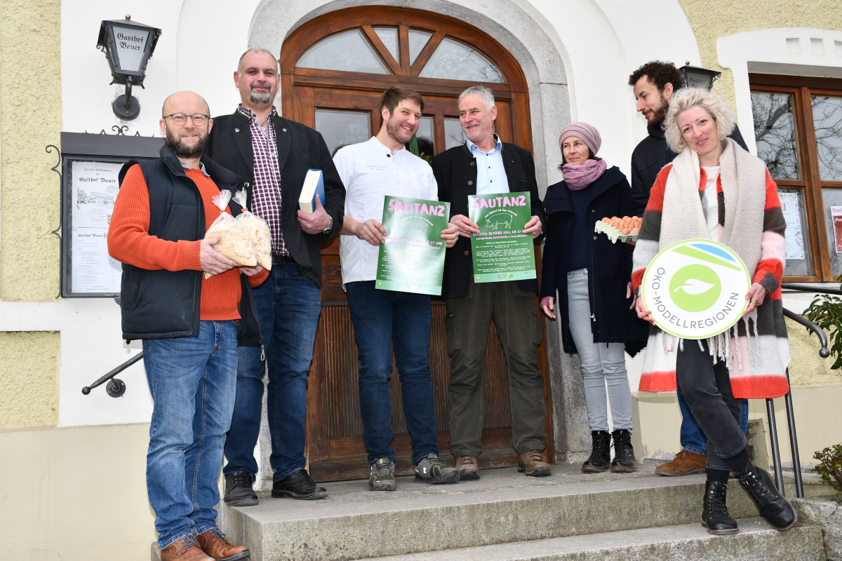 Gruppe Menschen steht vor Wirtshaus