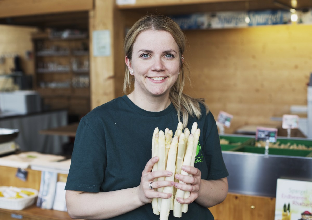 Julia Fröhlich-Kügel in ihrem Hofladen mit Bio-Spargel in ihren Händen
